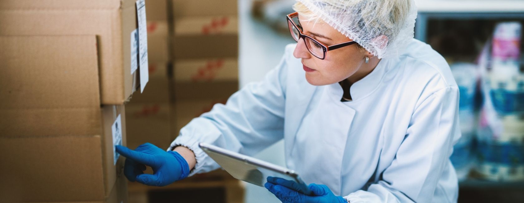 Female worker checking stack of boxes
