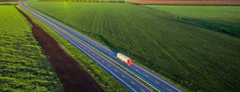 Truck on road between fields