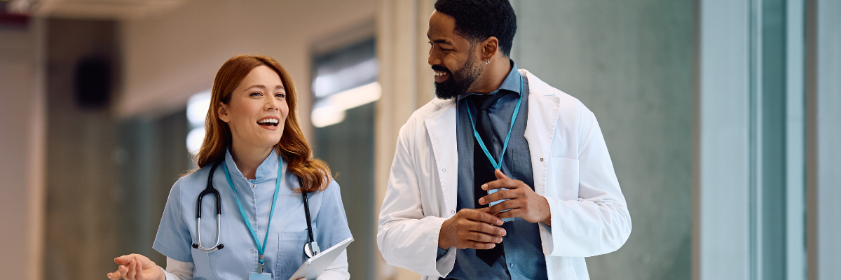 Male doctor and female nurse walking down corridor