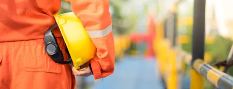 A person carrying a helmet for protection
